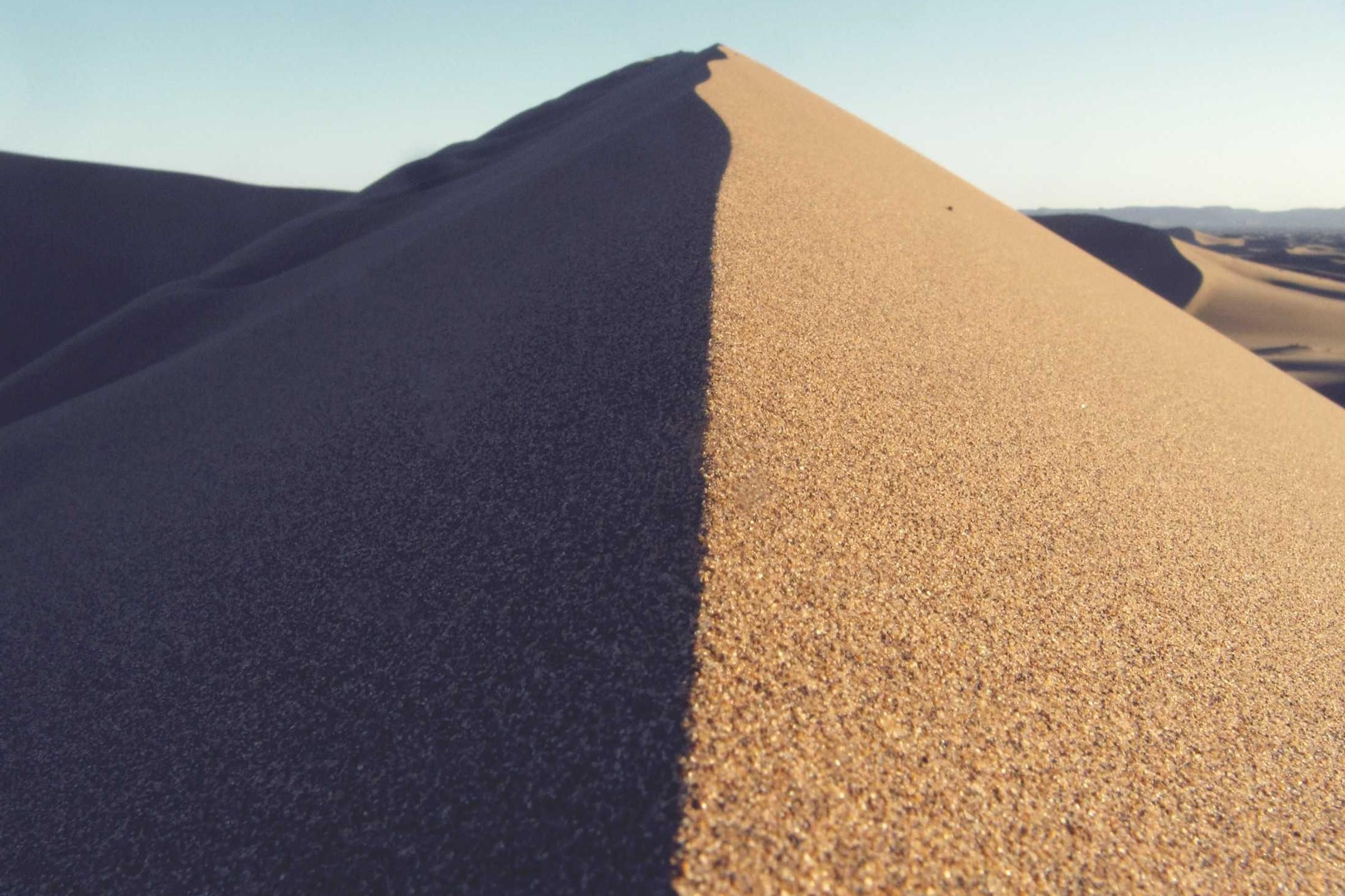 قمة كثيب رملي في ضوء العصر